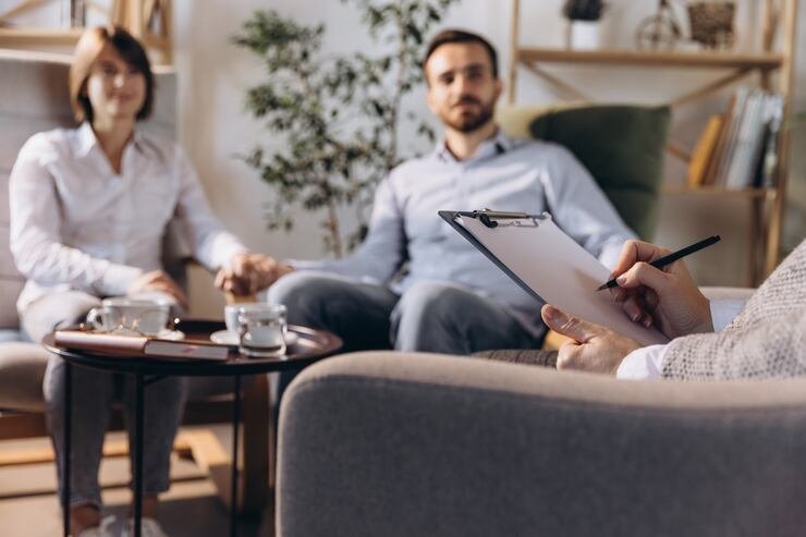 Çift terapisi sırasında psikologla görüşen bir çift; ilişki danışmanlığı sürecinde iletişim çalışması yapıyor.